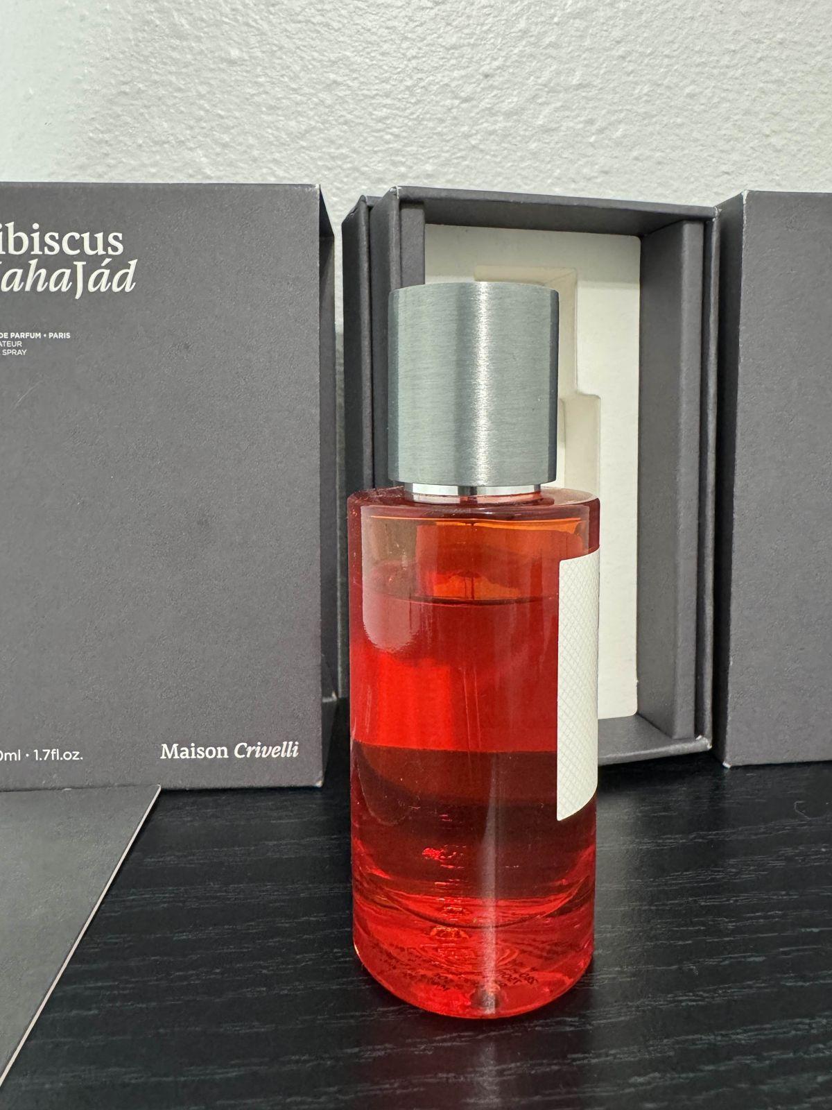 A fragrance bottle standing in its open box